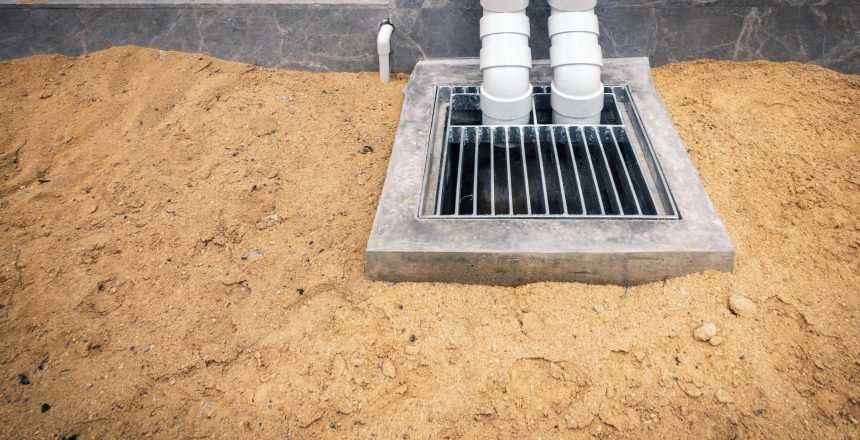PVC pipeline roofing drainage downspout and concrete manhole at construction site.